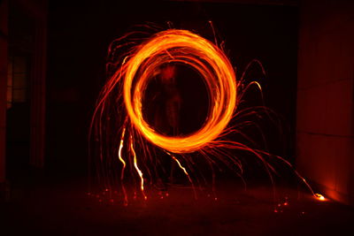 Man spinning wire wool at night