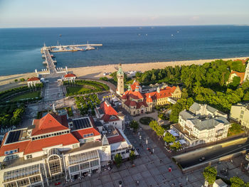 High angle view of buildings by sea against sky