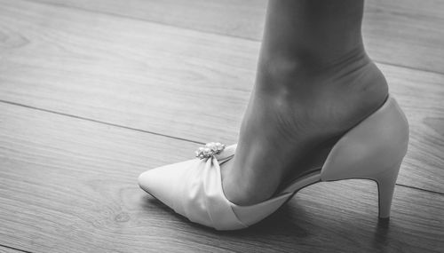 Low section of woman legs on hardwood floor