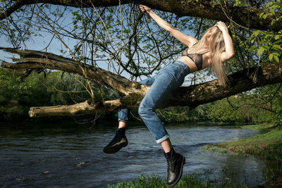 Full length of young woman jumping in lake