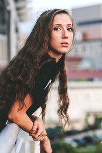 Portrait of woman leaning on railing