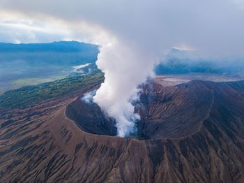 Smoke emitting from volcanic mountain against sky