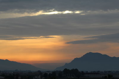 Scenic view of silhouette mountains against romantic sky at sunset