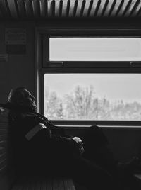 Man sitting by window in train