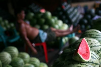 Defocused image of man selling watermelons at market stall