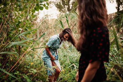 Young woman standing amidst plants on field