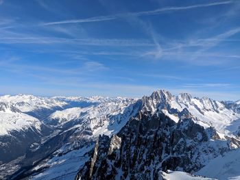 Scenic view of snowcapped mountains against blue sky