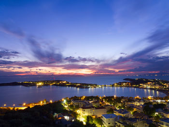 High angle view of illuminated cityscape against sky at night