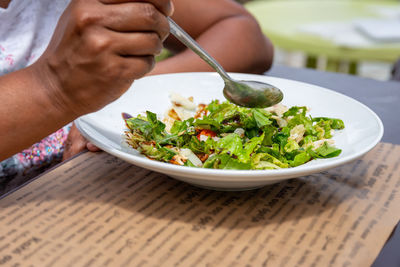 Midsection of person having food on table