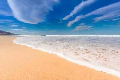 Scenic view of beach against blue sky