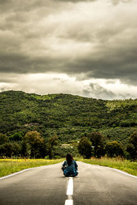 Rear view of person on road against sky