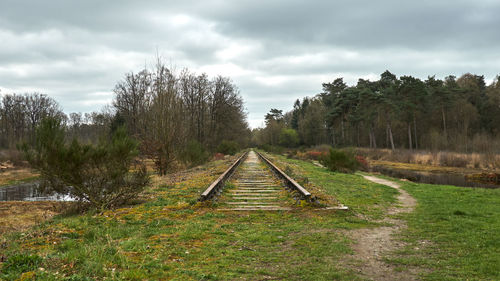 Railroad tracks on field against sky