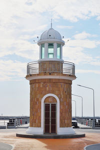 Lighthouse by sea against sky