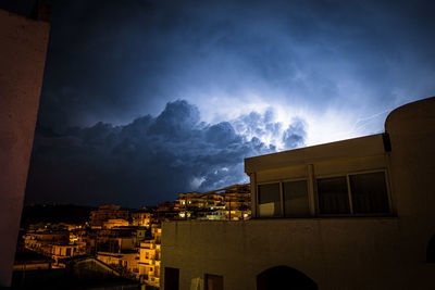 Low angle view of illuminated buildings against sky at night