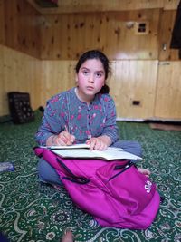 Portrait of boy sitting on book