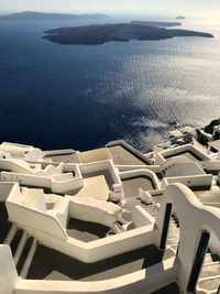 High angle view of chairs by sea against sky