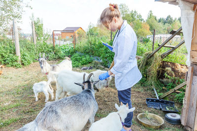 Side view of woman with dog on field