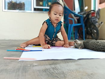 Cute girl sitting on table at home