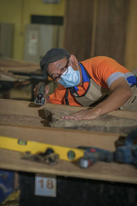 Carpenter wearing mask working at workshop