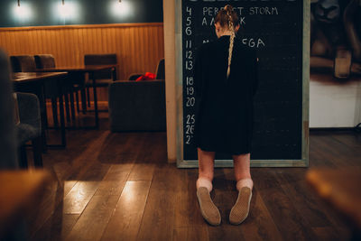 Low section of woman standing on hardwood floor in restaurant