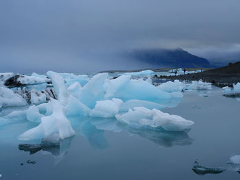 Frozen lake against sky during winter