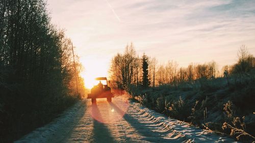 People walking on footpath at sunset