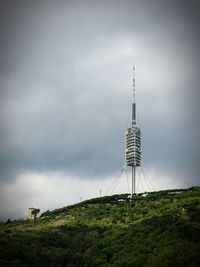 Communications tower on land against sky