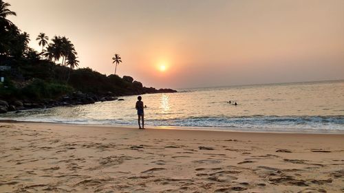 Silhouette of people on beach at sunset