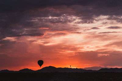 Silhouette hot air balloon against sky at sunset