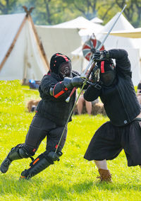 Show fight of medieval knights on a battlefield at the medieval market spectacle