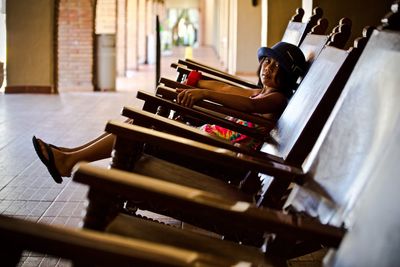 Portrait of girl sitting on chair in corridor