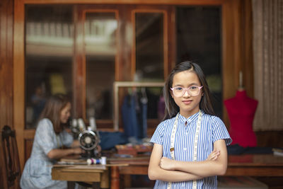 Portrait of smiling girl standing against wall