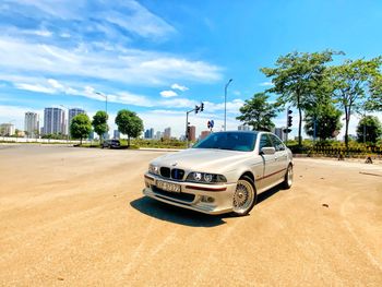 Car on road in city against sky