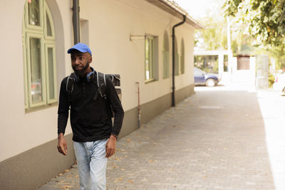 Side view of young man standing on street