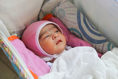 High angle view of cute baby sleeping on bed at home