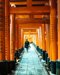 Rear view of man walking in corridor of building