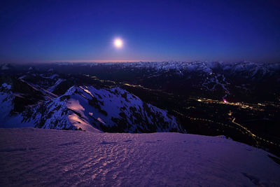 Scenic view of snowcapped mountains against sky at night