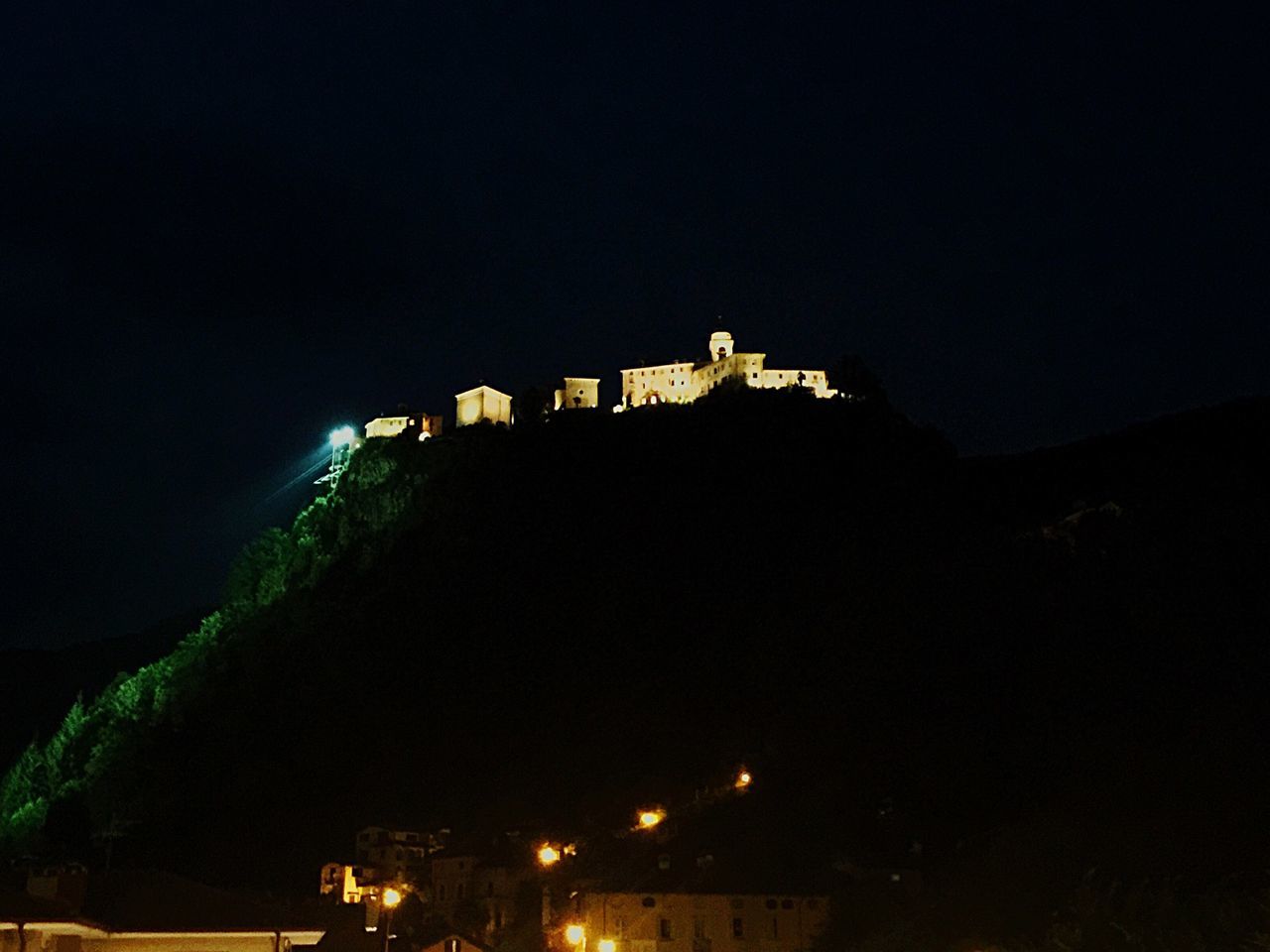 architecture, built structure, building exterior, night, illuminated, city, sky, copy space, clear sky, mountain, dark, residential building, outdoors, low angle view, no people, residential structure, tree, dusk, building, cityscape