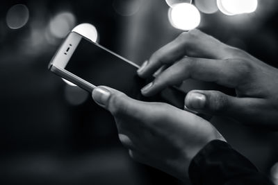 Close-up of man using mobile phone at night