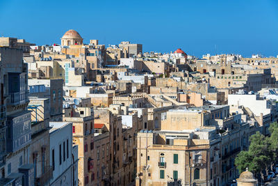 Buildings in city against clear blue sky