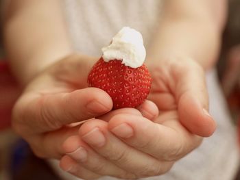 Close-up of hand holding strawberry
