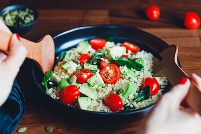 Midsection of person holding salad in bowl