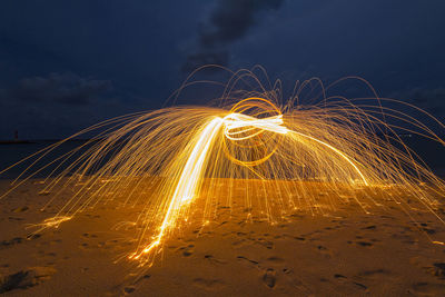 Wire wool on shore against sky at night