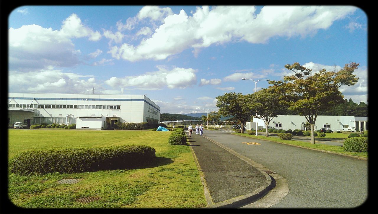 transfer print, sky, grass, cloud - sky, auto post production filter, road, building exterior, architecture, built structure, cloud, tree, transportation, the way forward, street, green color, road marking, cloudy, lawn, empty, day