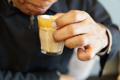 Midsection of man drinking glass