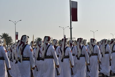 Panoramic view of people in row against sky