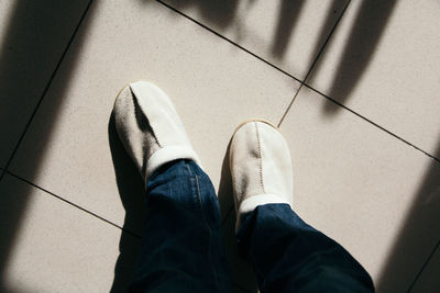 Low section of man standing on tiled floor