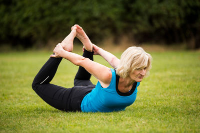 Full length of woman with arms raised on field