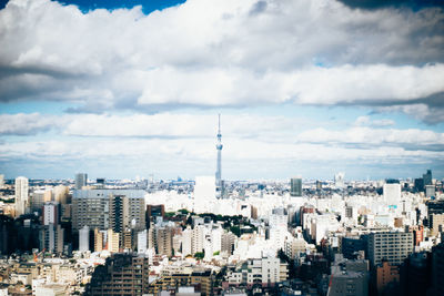 Buildings in city against cloudy sky