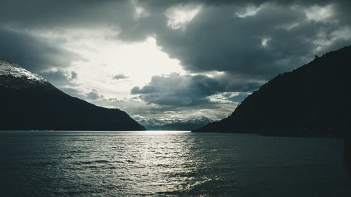 Scenic view of sea and mountains against sky